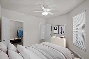 A bedroom with a bed and a ceiling fan